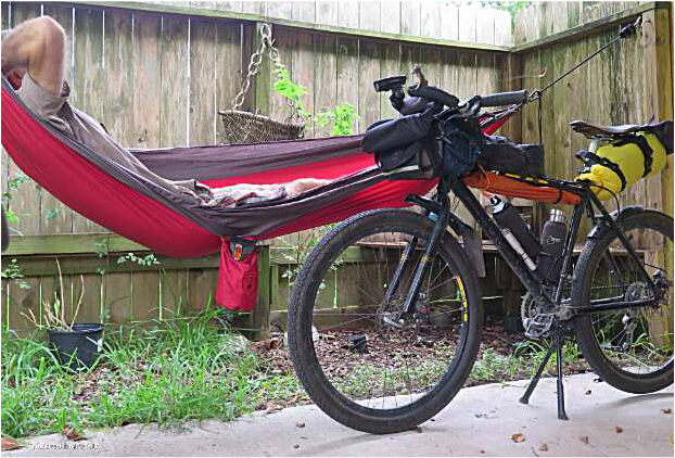 Picture of cyclist resting in hammock with bike for bike packing