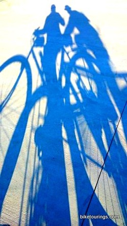 Picture bike ridiers shadows on gravel road