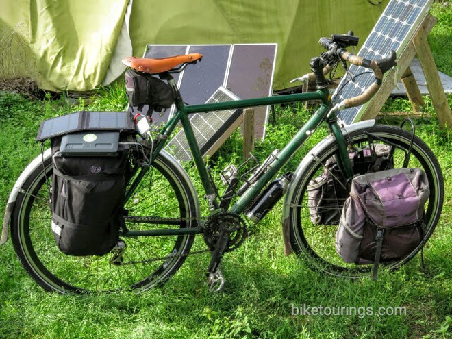 Picture of touring bike with solar panels and gadgets being charged